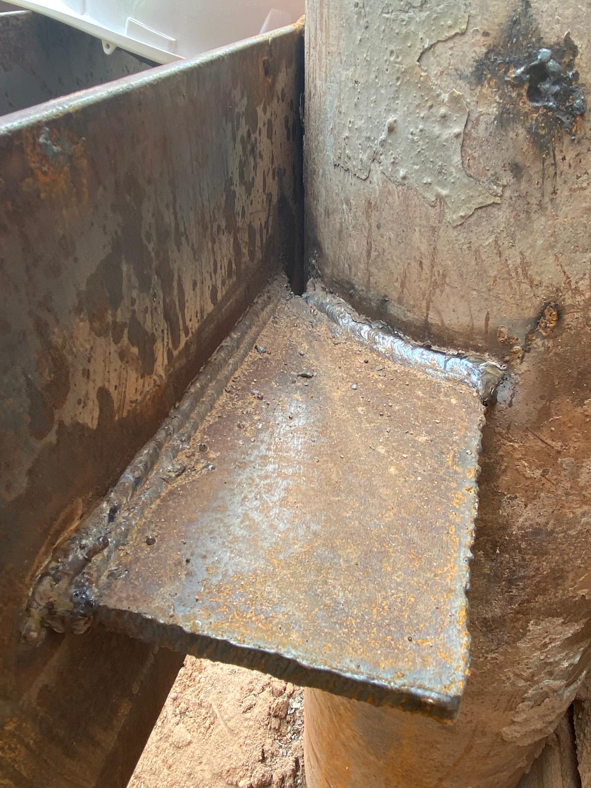 Close view of a finished fillet weld joining a steel gusset plate to a column.
